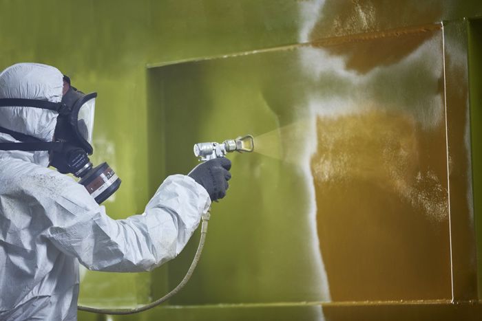 BIlete av ein person som sprøytemalar ein vegg